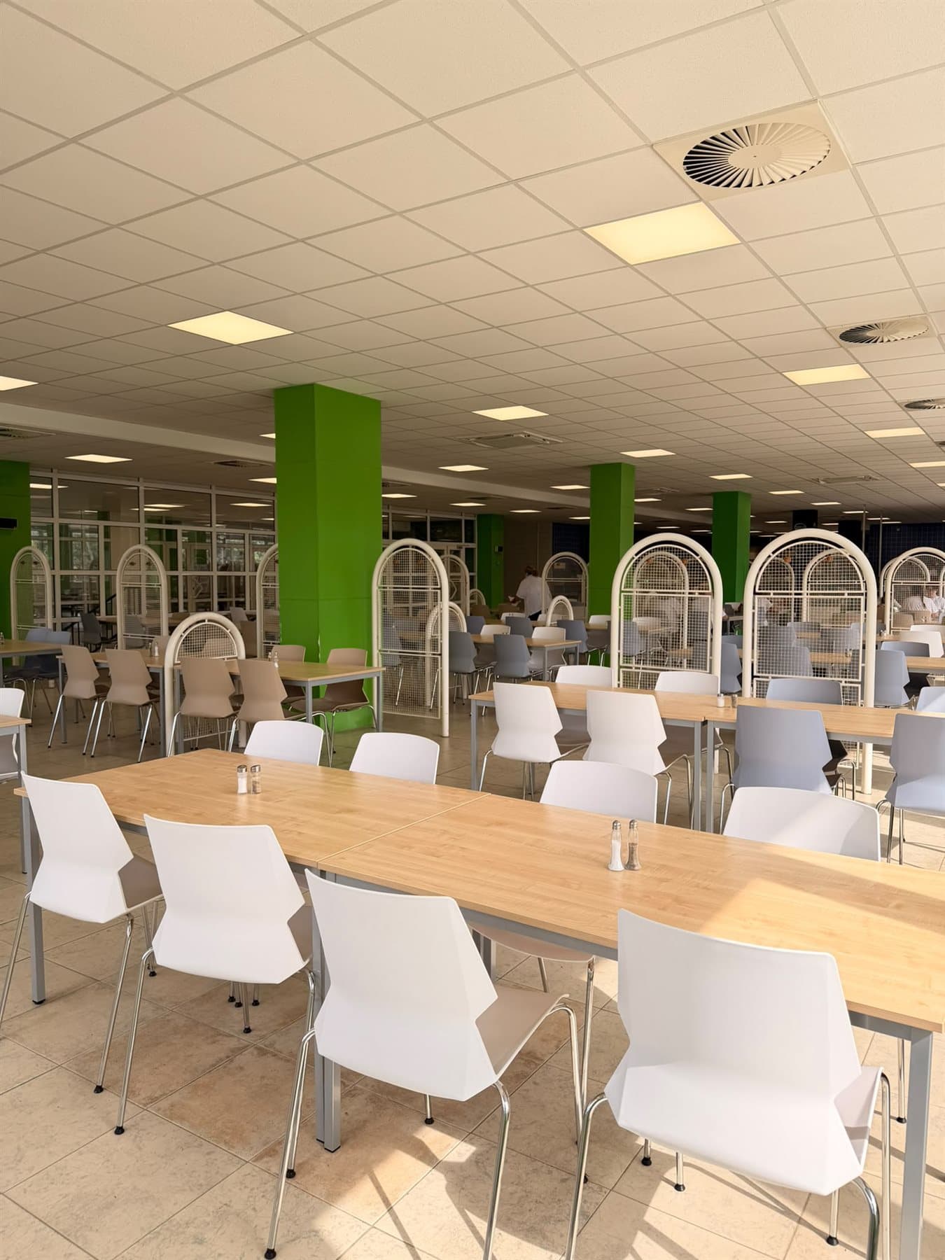 Prostor k posezení v jídelně MASI-CO food — dřevěné stoly a denní světlo